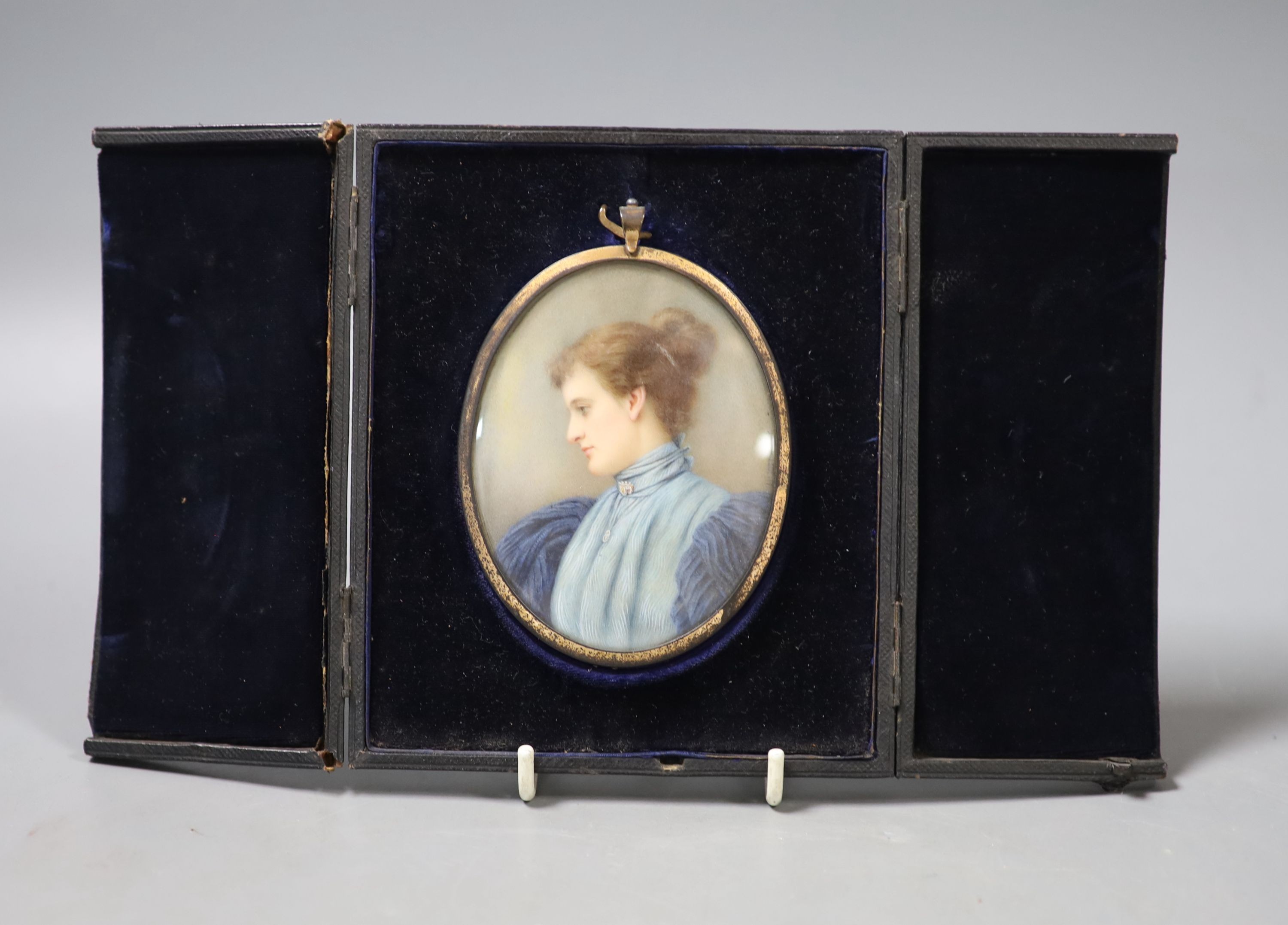 A late Victorian cased oval miniature on ivory, signed Elliott & Fry, portrait of a young woman wearing a blue dress, with hairpiece back, 9cm